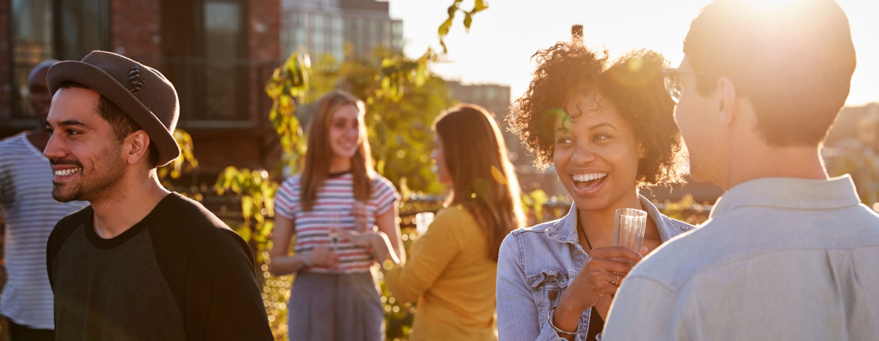 a group of people standing outside talking at sunset