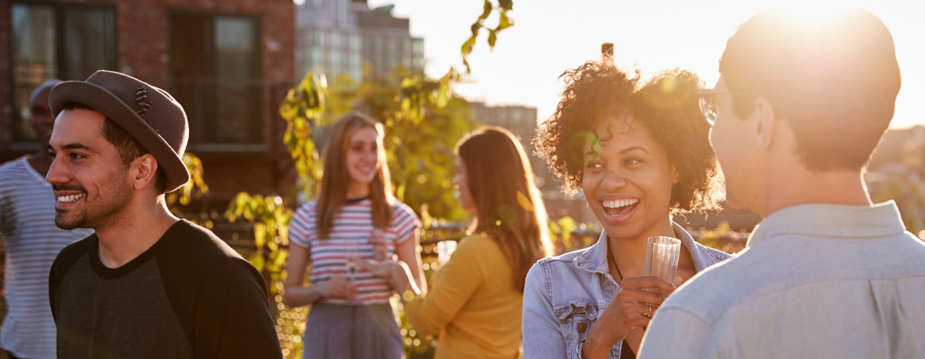 a group of people standing outside talking at sunset