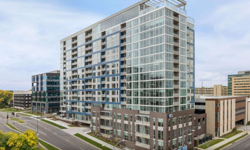 EO Madison Yards high-rise apartment exterior with glass curtain wall and blue accent panels