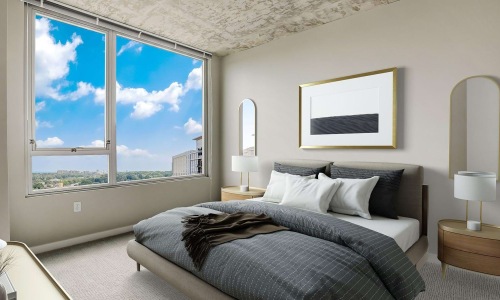 Primary bedroom with upholstered platform bed, wood nightstands, and sky views