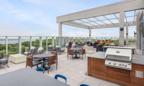 Rooftop terrace with outdoor grill station, dining tables, and Lake Monona views