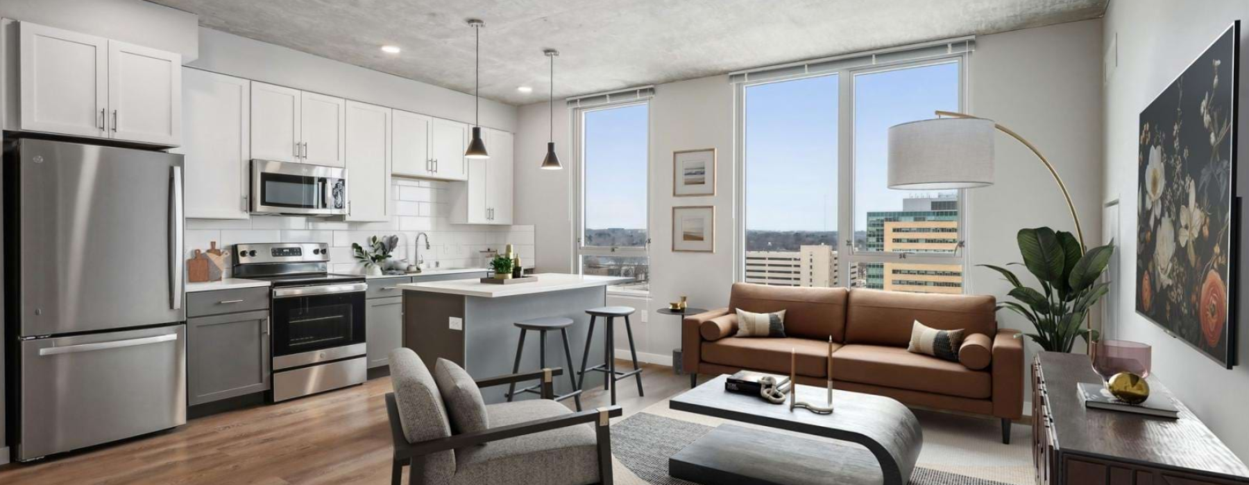  Studio apartment kitchen with stainless appliances, white cabinets, and city view windows