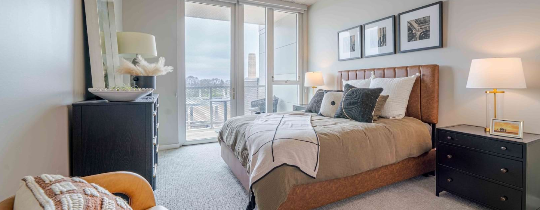 Primary bedroom with leather platform bed, balcony door, and city views