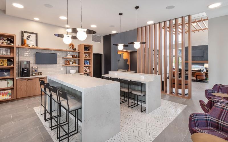 a community kitchen and dining room with seating tables and tv
