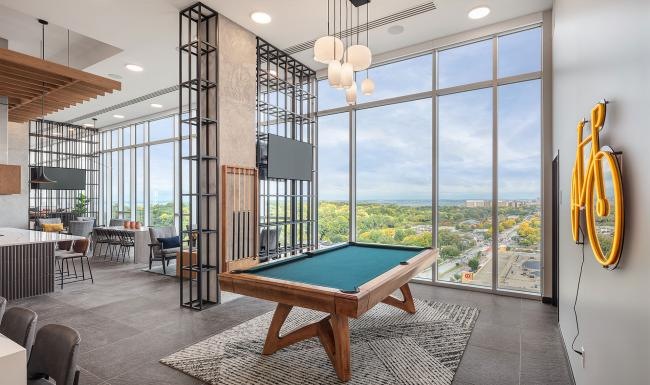 a room with a pool table and large windows